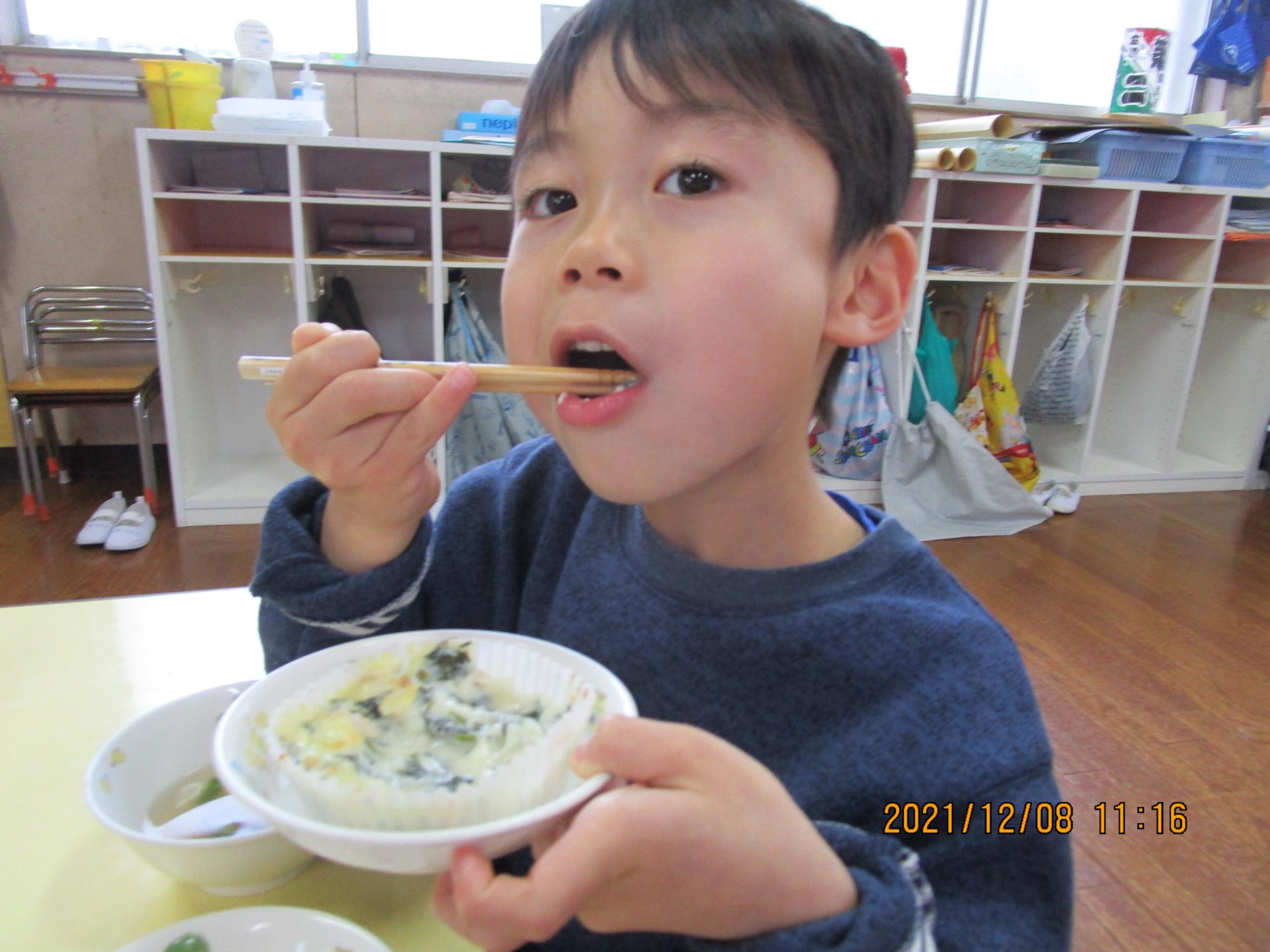 画像:給食をほおばる男児