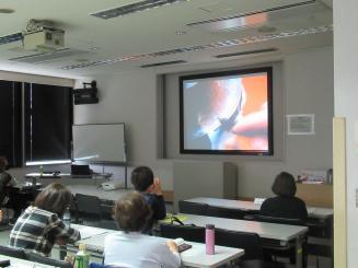 スクリーンに映し出された増村さんの制作工程の映像を見る受講者の写真