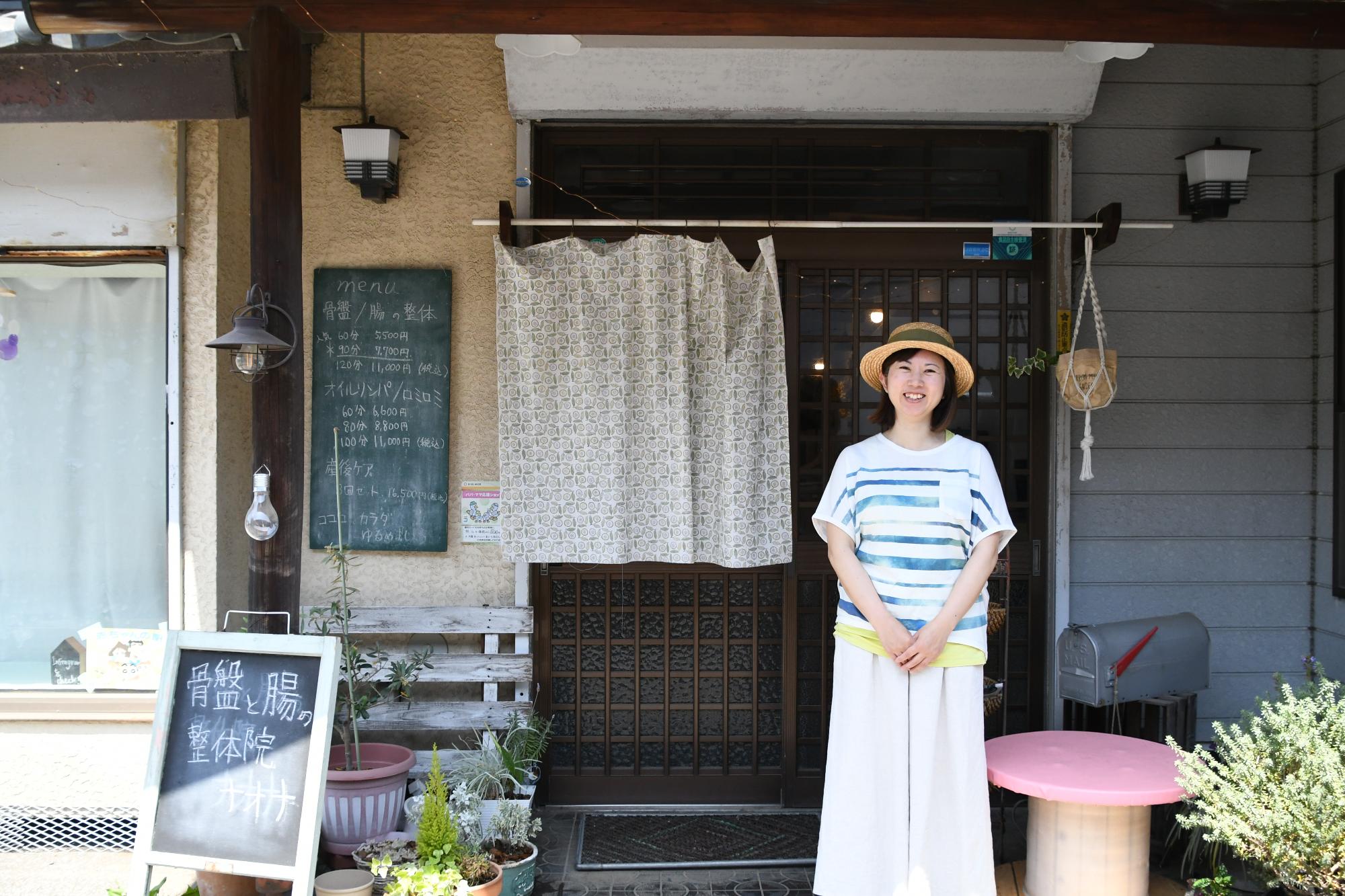 お店の前で笑顔で立つナオナさん