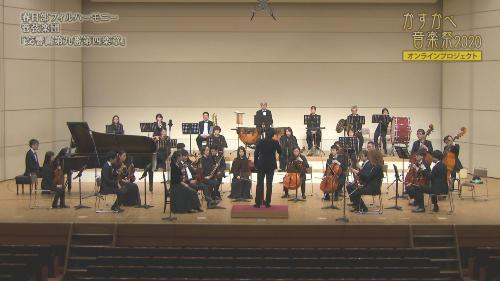 オーケストラの人たちが舞台上で様々な楽器を演奏している、春日部フィルハーモニー管弦楽団がステージ上で演奏をしているかすかべ音楽祭2020の写真