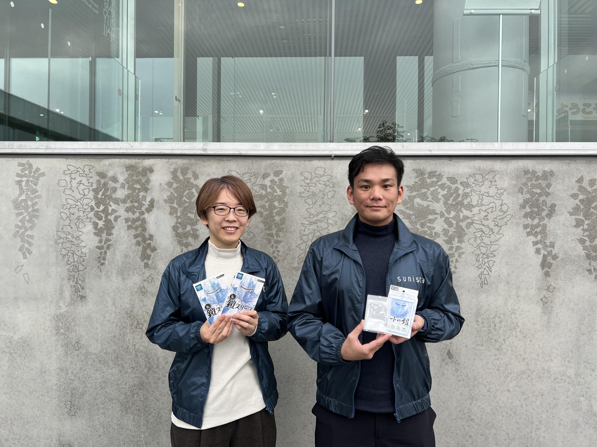 商品を手に持って微笑む鈴木俊介さんと鈴木由美さん