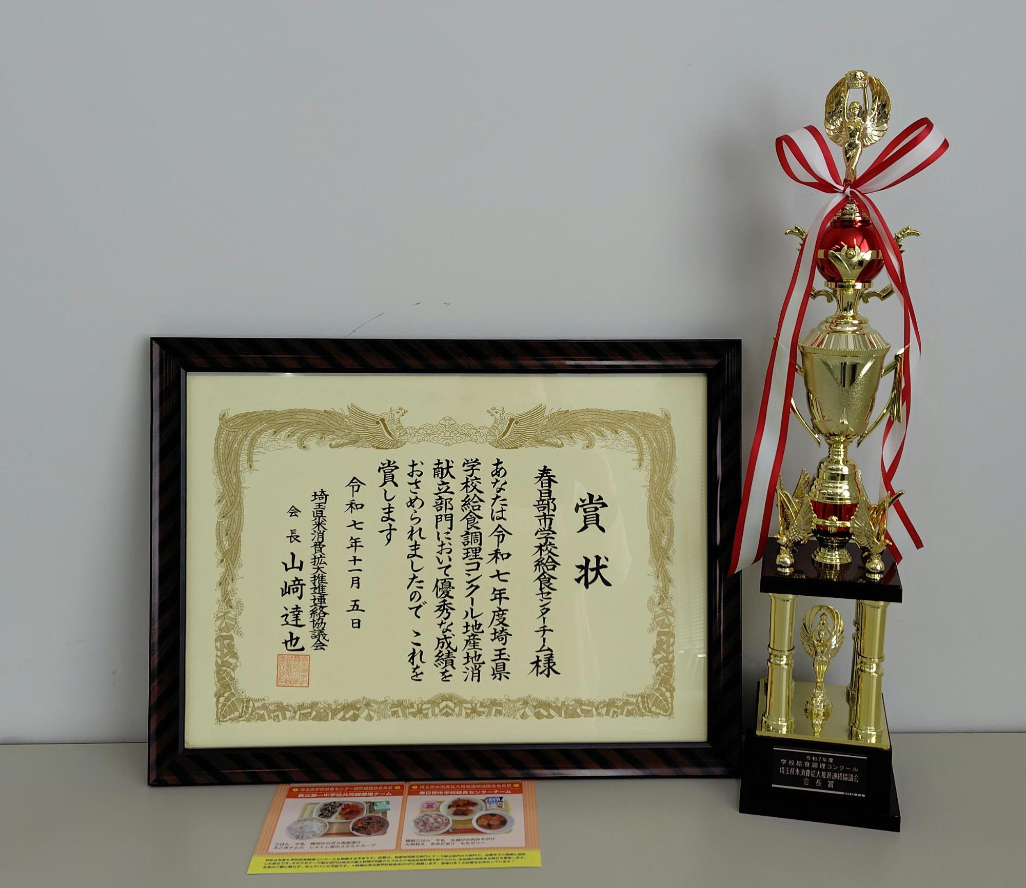 赤いリボンがついた調理コンクールのトロフィーと、賞状が並べて置かれている写真