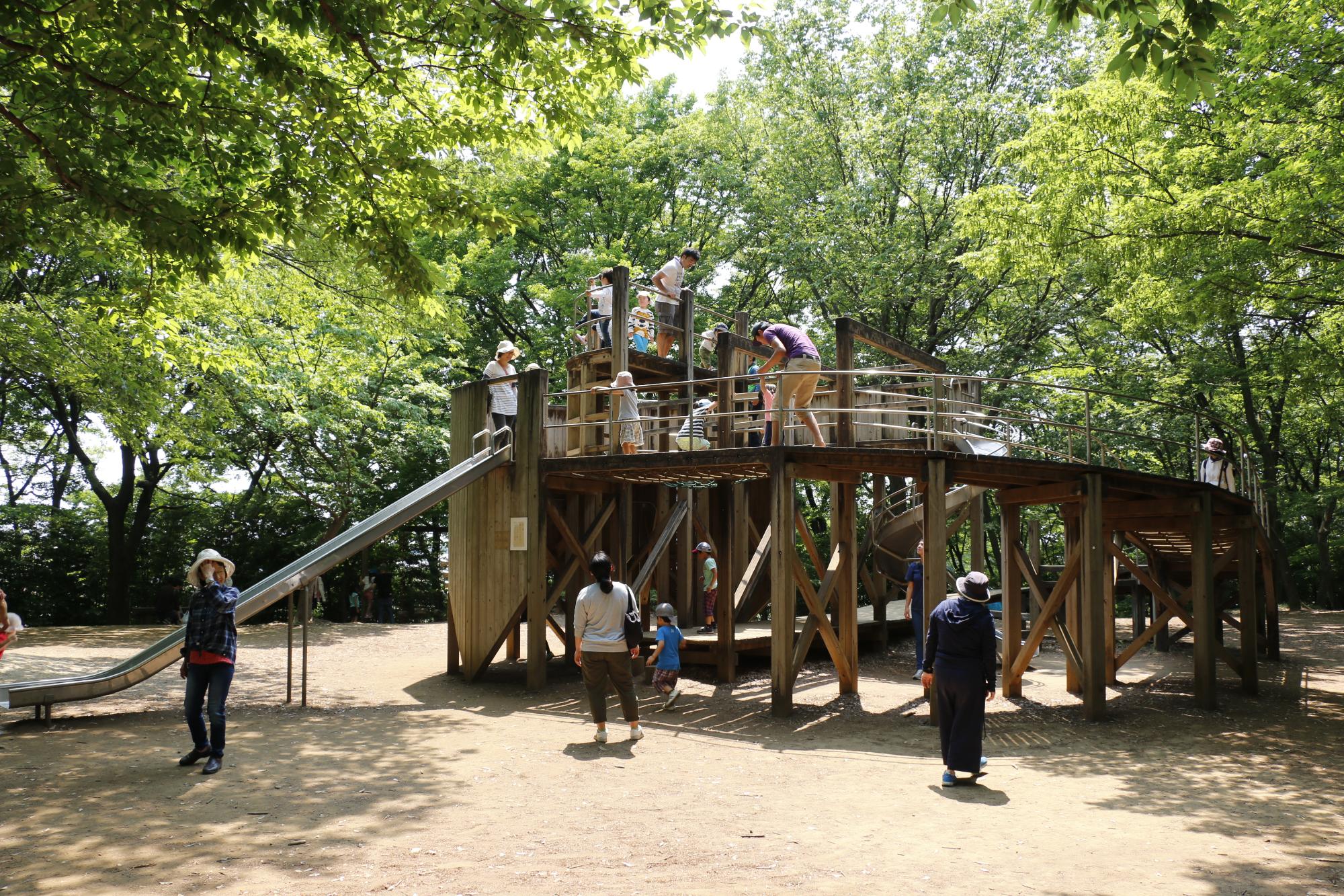 内牧公園の遊具と遊んでいるこどもたちの写真