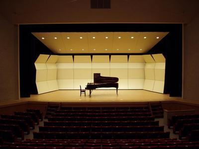 中央にグランドピアノの置かれた小ホール（定員401人）ステージの写真