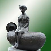 岩に座り膝の上に手を揃え遠くを見つめる少女の銅像の写真