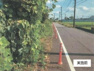 幸松小学校通学路の外側線に沿ってポールが設置されている直線の道の写真