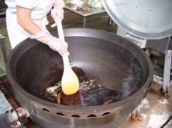 大鍋に入った合わせ調味料を混ぜている様子の写真