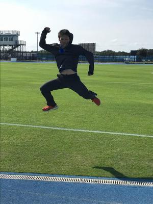 芝の上で大きくジャンプしているトレーニングの様子の写真