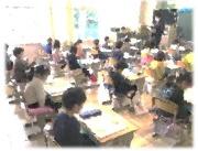 教室で多数の生徒が授業を受けている写真