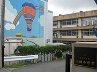 壁面にカラフルな気球が描かれた「川辺小学校」の写真（「川辺小学校」のサイトへリンク）