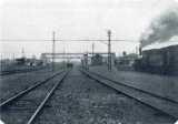 地平線に向かって続く春日部駅の線路の白黒写真