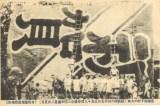 祝いの言葉が書かれた大凧の前で撮影された白黒写真