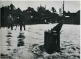 荒れた川面の奥に立つ人の様子が写った新町橋の白黒写真
