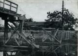台風によって崩れている木橋の白黒写真
