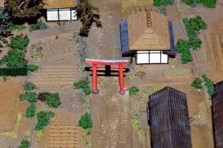 農村部の中央の道に鳥居が建ててある八坂神社ののミニチュア模型の写真