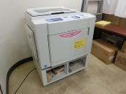 白い印刷機が置かれている幸松地区公民館印刷室の写真