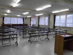 広々とした白いフロアの武里東公民館大会議室（机といすを置いた状態）の写真