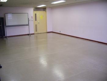 ピンク色の壁と木製フローリングの床が特徴的な豊春第二公民館第二会議室の写真