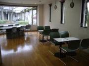 緑色の4人掛けの机が並ぶ豊春地区公民館談話室の写真