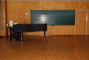 部屋全面が木材で出来た部屋にグランドピアノが置かれている庄和地区公民館音楽室の写真