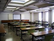 天窓から外の光が差し込む武里大枝公民館研修室（机といすを置いた状態）の写真