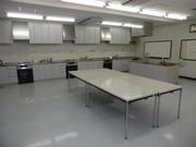 白を基調とした部屋に白いキッチン設備が用意されている幸松地区公民館実習室の写真