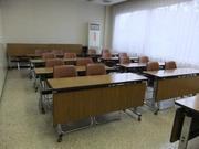 木製の机と椅子が並べられた粕壁南公民館学習室の写真