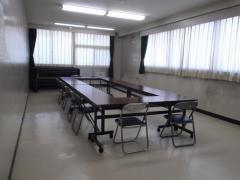 グレーを基調とした広々とした空間の武里東公民館講習室（机といすを置いた状態）の写真