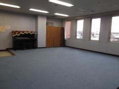 アップライトピアノが置かれている武里地区公民館音楽室（ピアノと反対側から）の写真