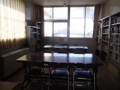中央の机が窓から差し込む光を反射している武里東公民館図書室の写真