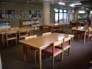 木製の机と椅子が並ぶ豊春地区公民館図書コーナーの写真