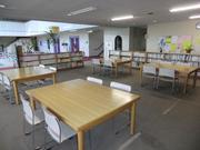 木製の机と本棚が並ぶ幸松地区公民館図書コーナーの写真