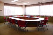 楕円枠の机に赤い椅子が並べられている豊野地区公民館会議室の写真