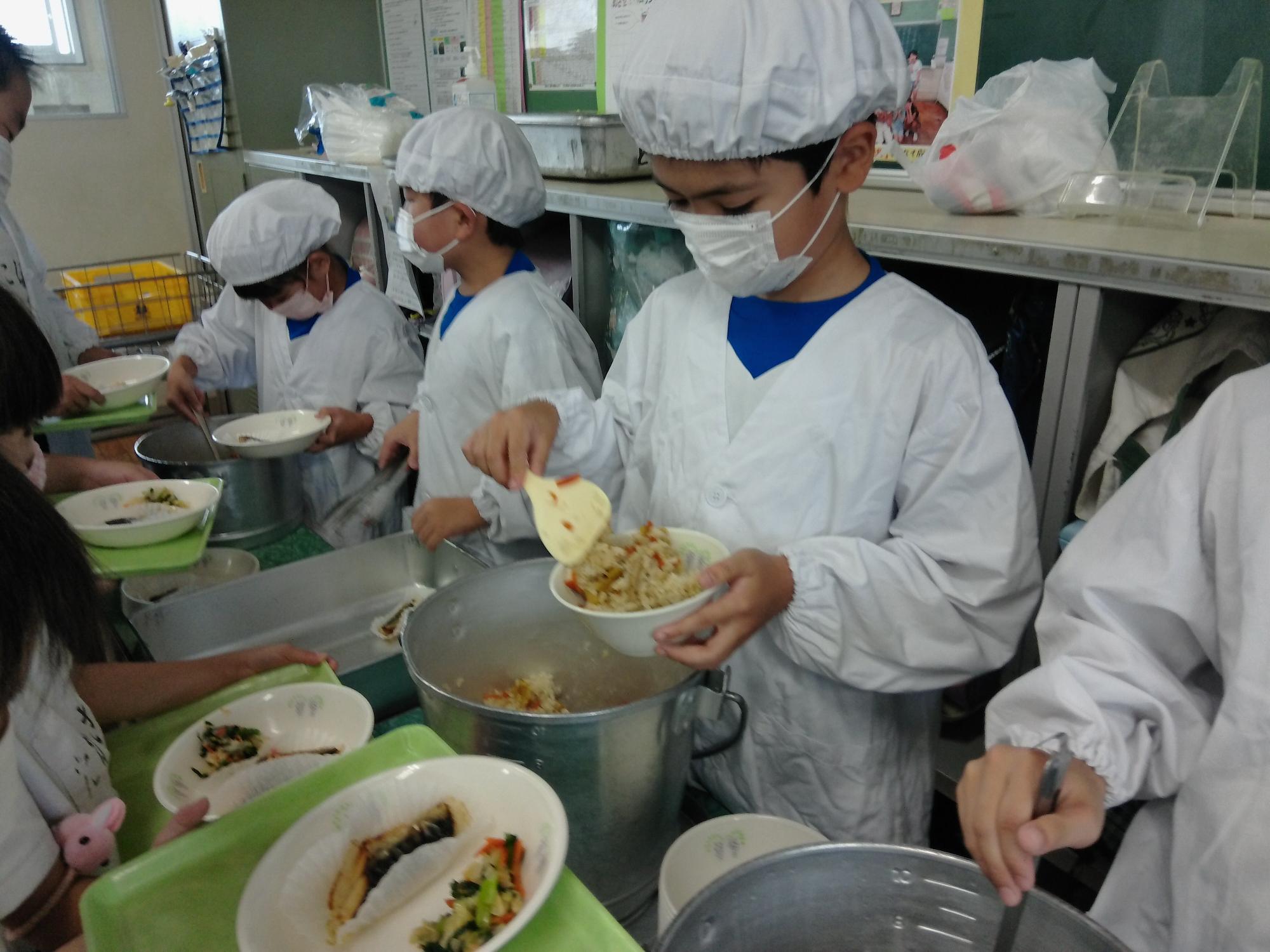 児童が給食を配膳している様子